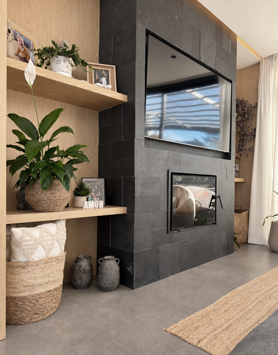 Hogar revestido en piedra oscura y equipamiento de madera en Casa 9 Greenland
