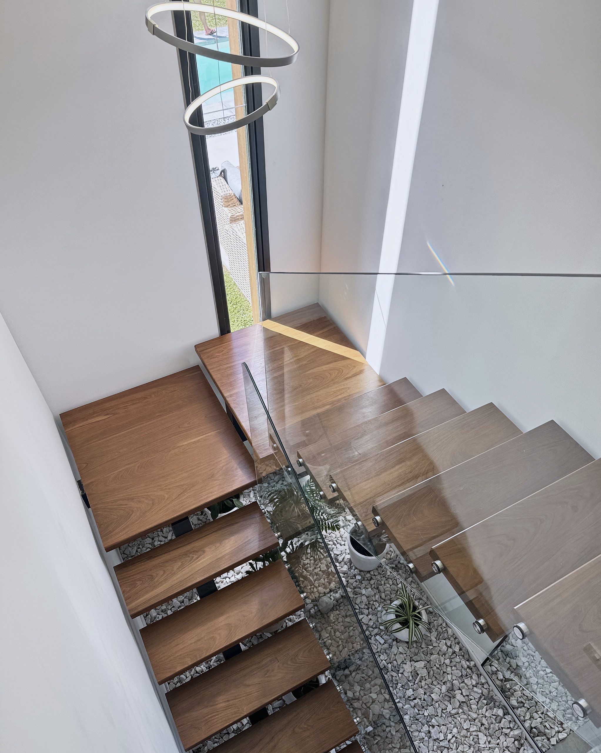 Detalle de escalera de madera con baranda de vidrio