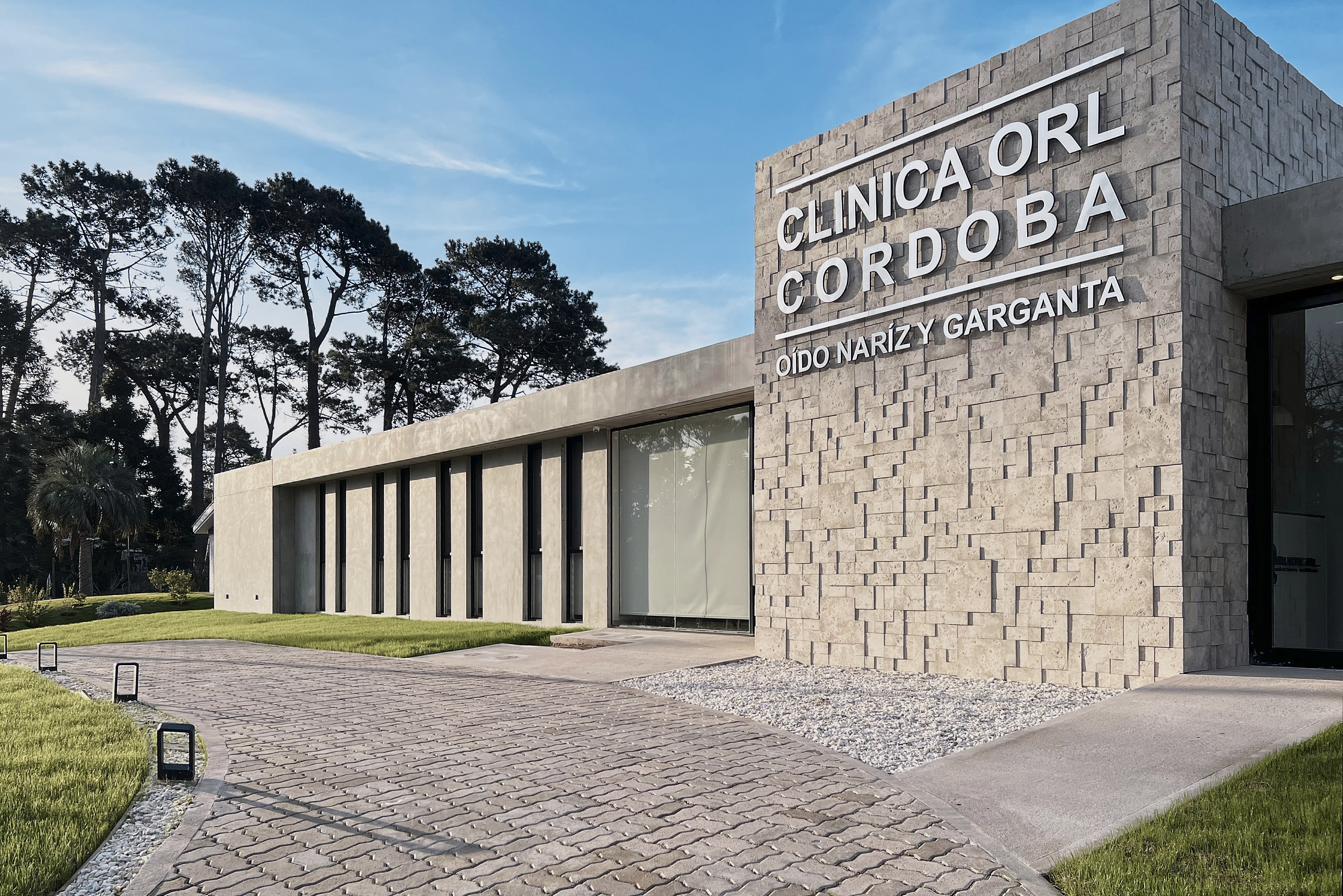 Acceso de Clínica ORL Córdoba con volumen revestido en piedra