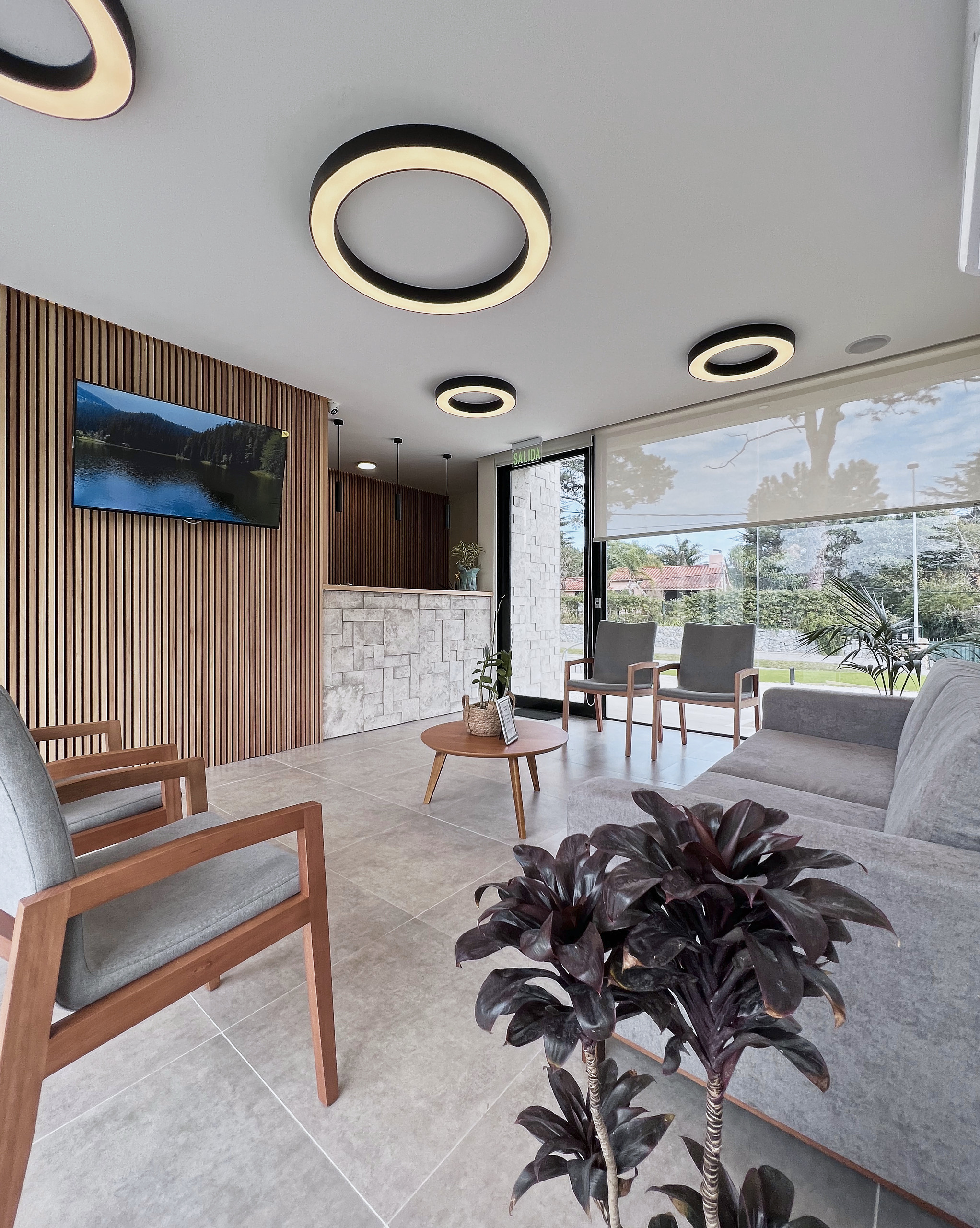 Sala de espera de Clínica ORL Córdoba con madera y luminarias circulares