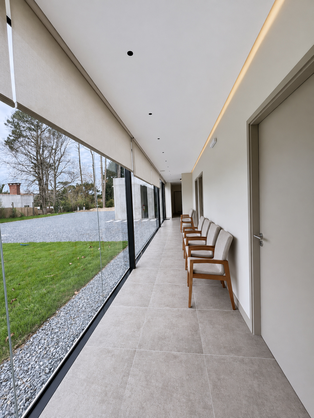 Circulación interior vidriada con asientos de madera