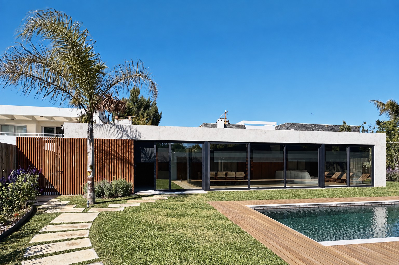 Fachada hacia el jardín y la piscina de Loma Verde